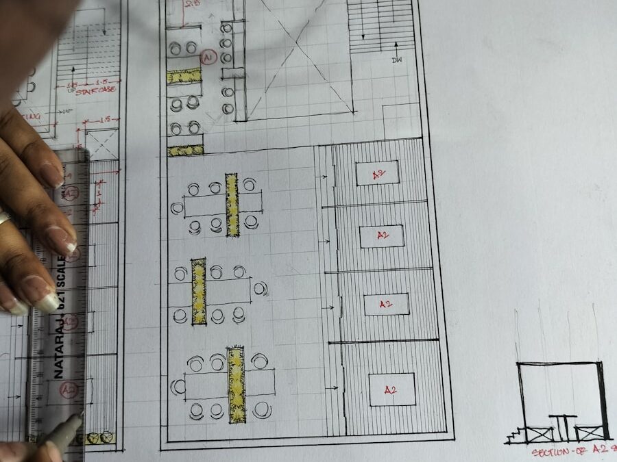 a person is drawing a floor plan on a piece of paper