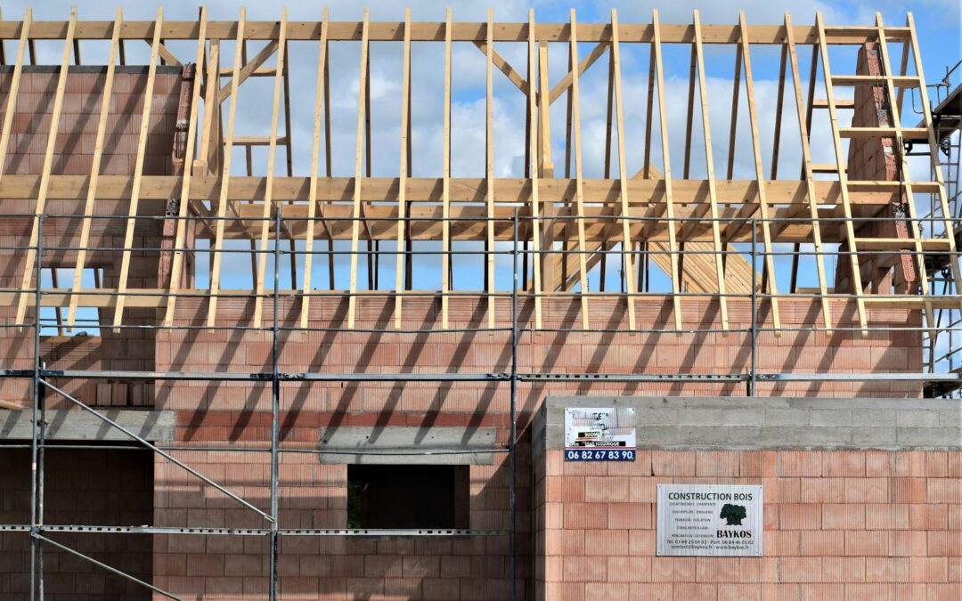Building under construction with wooden roof trusses.